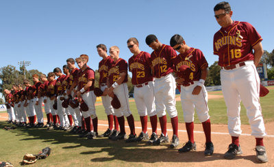 Members of Wilson High's baseball team bow their heads at Blair Field during a moment of silence for former teammate Gary DeVercelly Jr., 18, who died Friday after drinking excessively at a fraternity house in Trenton, N.J. (Stephen Carr / Press-Telegram)